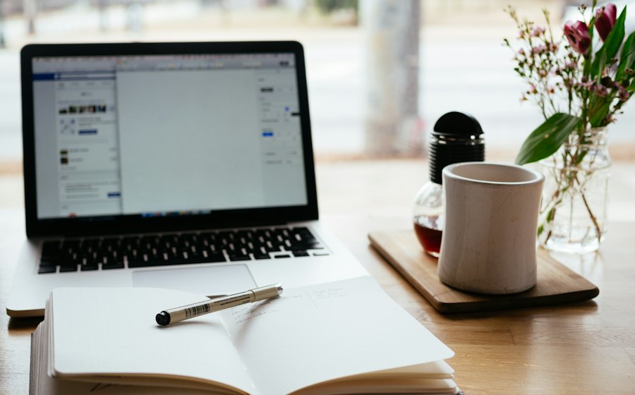 Laptop y libreta para escribir artículos de blog